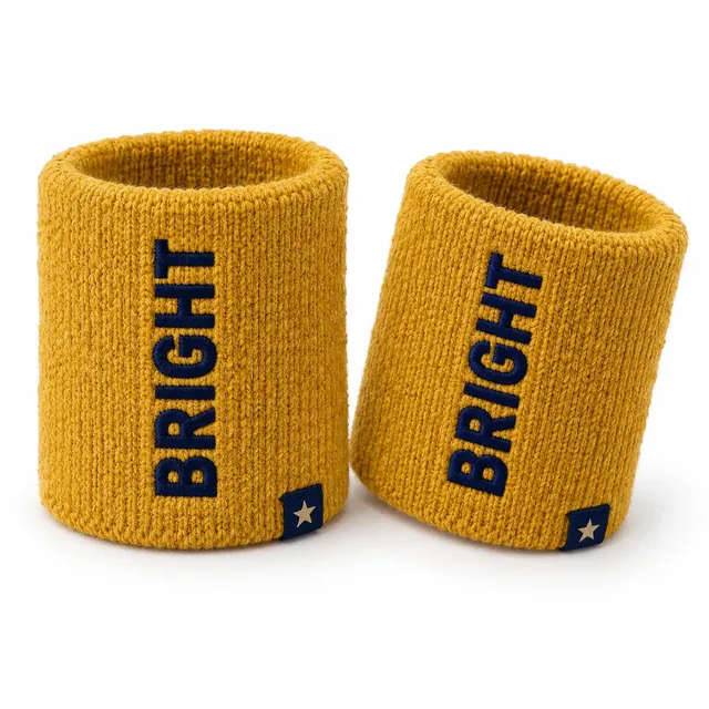 Mustard yellow woolen wristbands with navy lettering knitted vertically and a small star tab